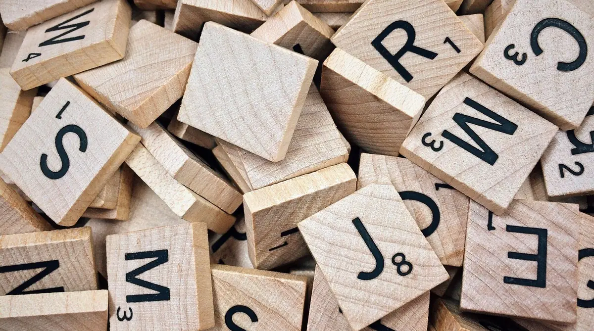 A pile of wooden letter tiles with point values